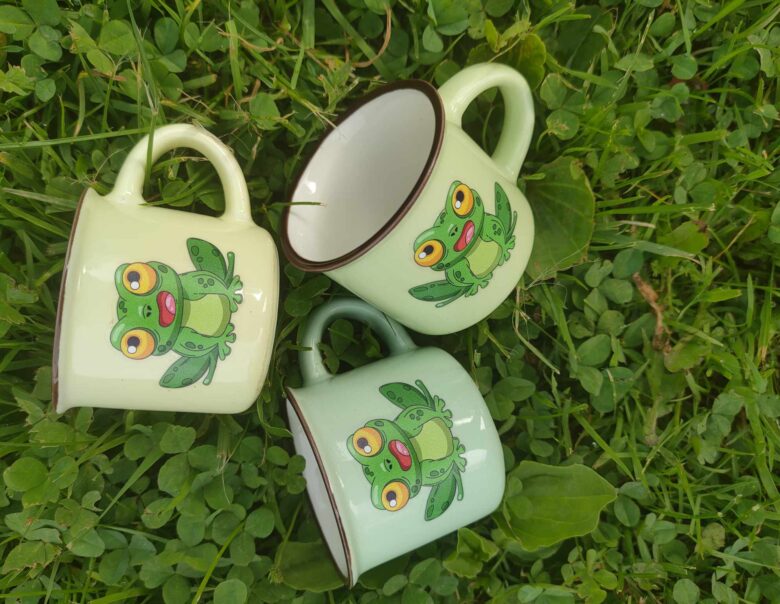 Tri skodelice z motivom žabe na travi, simbol letošnjega piknika.
